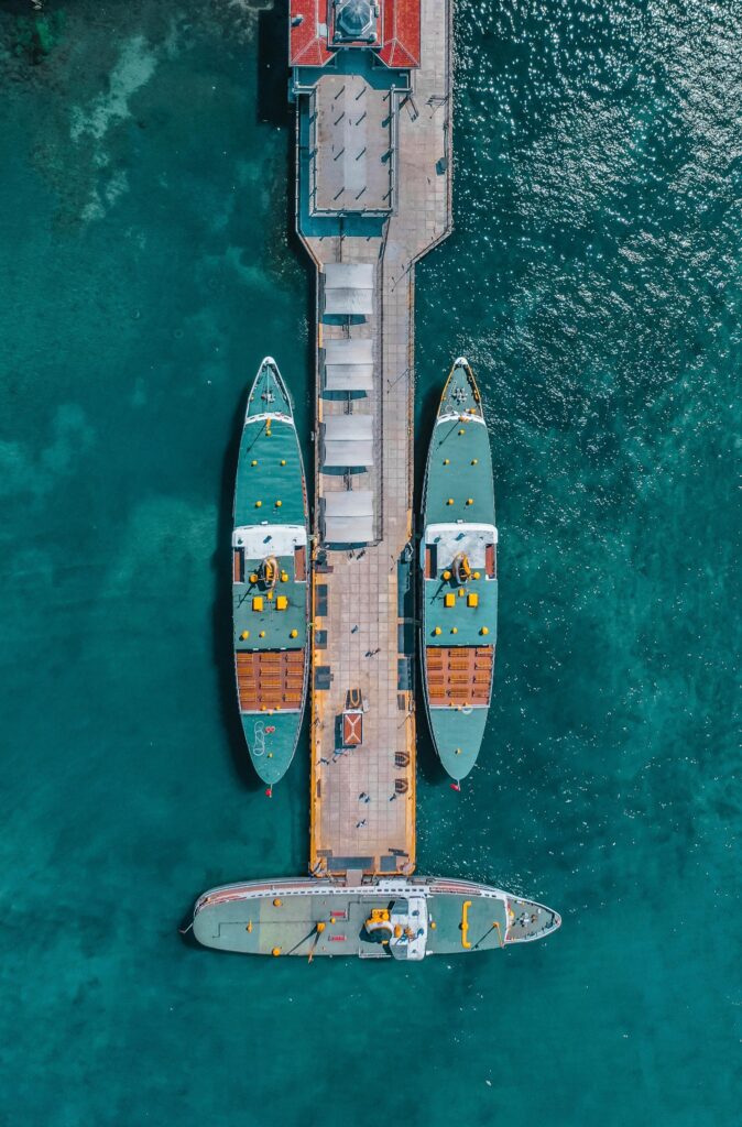 Drone shot of boats docked at a vibrant port in İstanbul, Turkey, on a sunny day.
